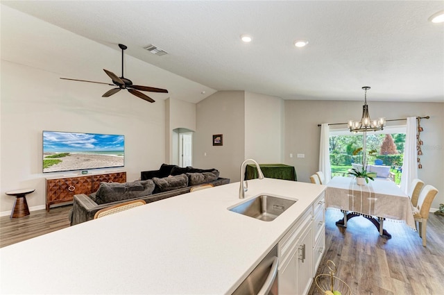 kitchen with a sink, visible vents, white cabinets, open floor plan, and light countertops