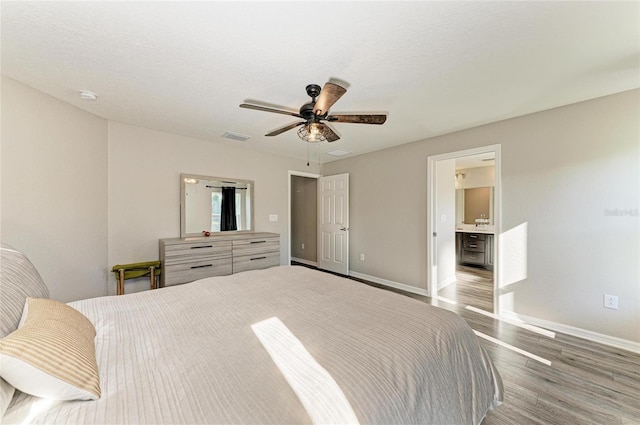 bedroom with a ceiling fan, a textured ceiling, baseboards, and wood finished floors