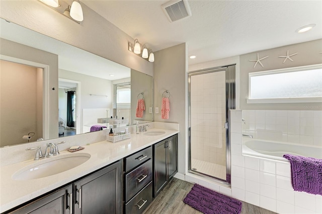 full bathroom featuring a stall shower, visible vents, a sink, and double vanity