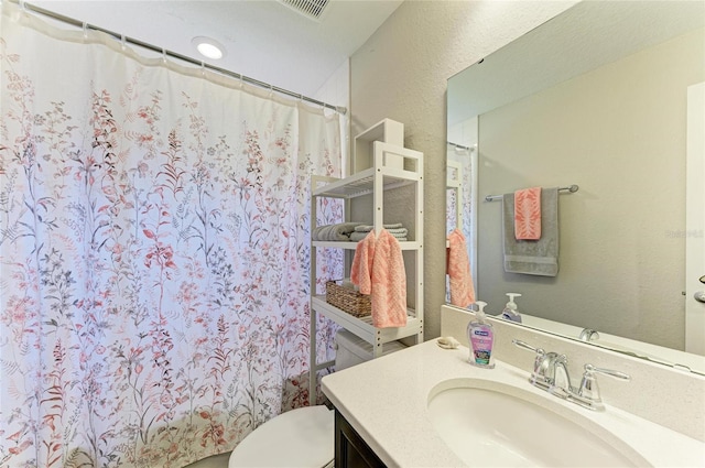 full bathroom with a shower with curtain, visible vents, vanity, and toilet