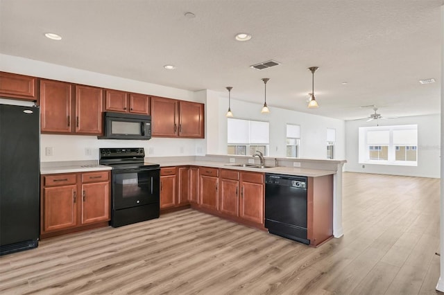 kitchen featuring light countertops, a sink, visible vents, and black appliances