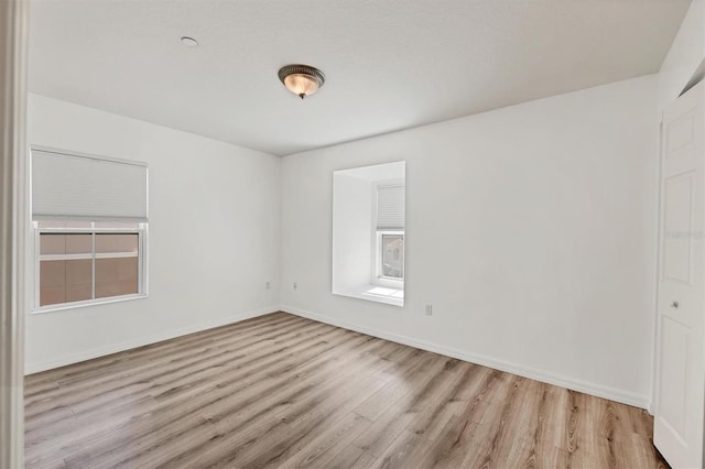 empty room featuring light wood-style flooring and baseboards