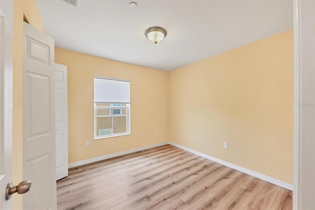 spare room with light wood-type flooring and baseboards