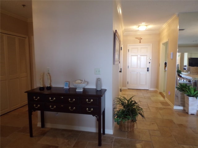 foyer with baseboards, ornamental molding, and stone tile flooring