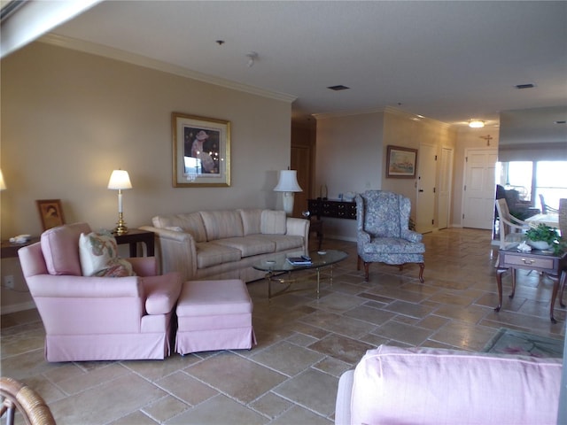 living room featuring ornamental molding, stone finish flooring, visible vents, and baseboards