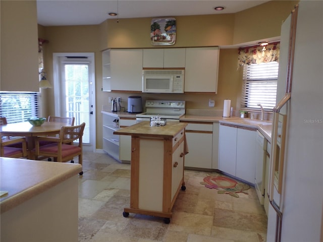 kitchen featuring stone finish floor, white appliances, wood counters, and white cabinetry