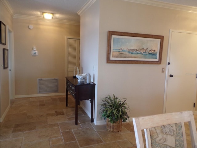 corridor with baseboards, visible vents, crown molding, and stone finish flooring