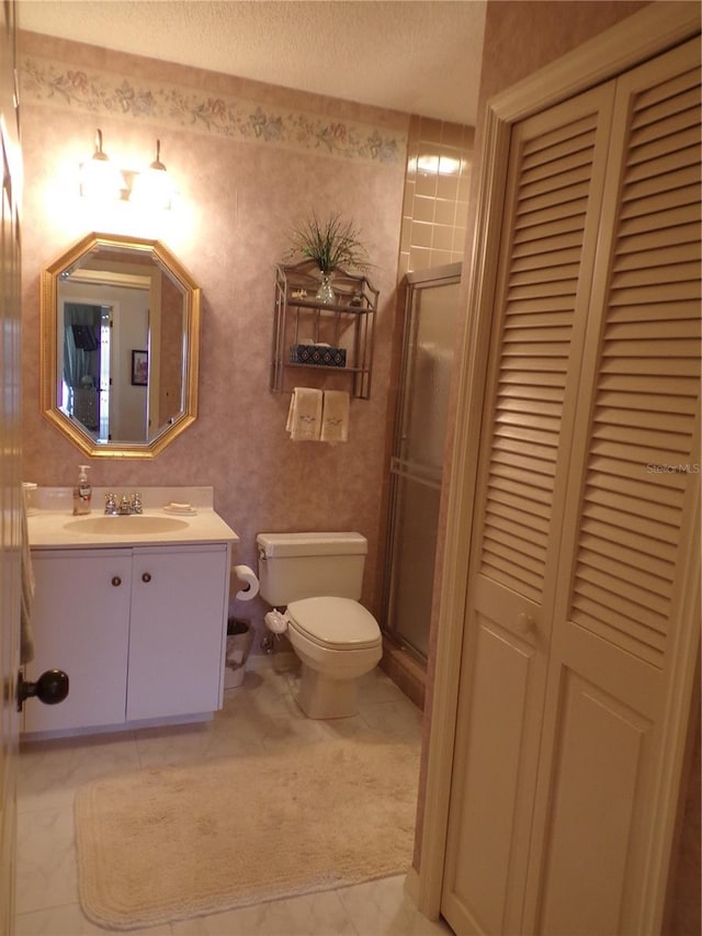 full bathroom featuring a textured ceiling, tile patterned flooring, toilet, vanity, and a closet