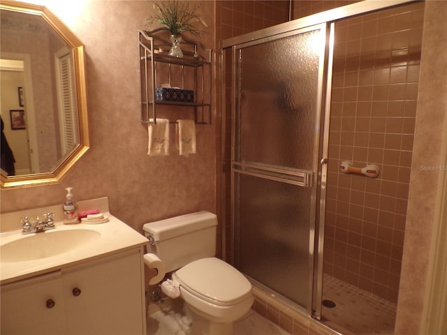 bathroom with toilet, a stall shower, and vanity