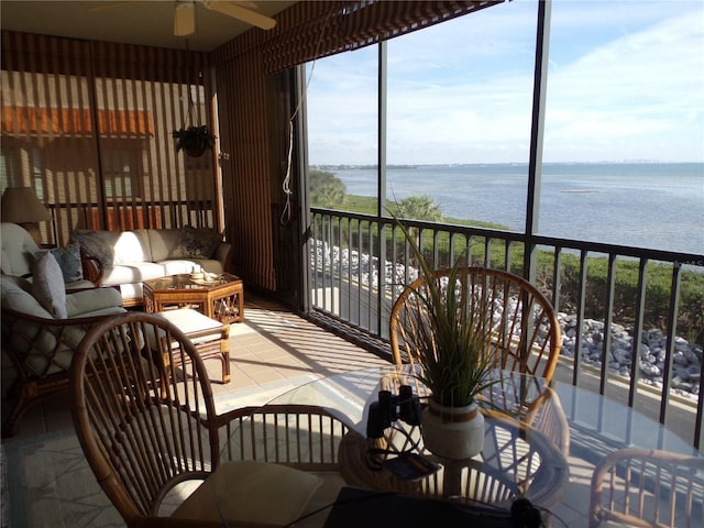 sunroom featuring a water view and ceiling fan