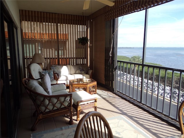 sunroom / solarium with a water view and ceiling fan