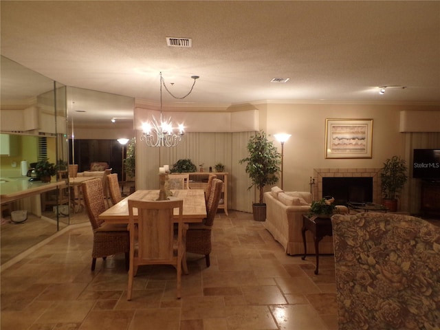 dining space with stone finish floor, visible vents, a textured ceiling, and an inviting chandelier