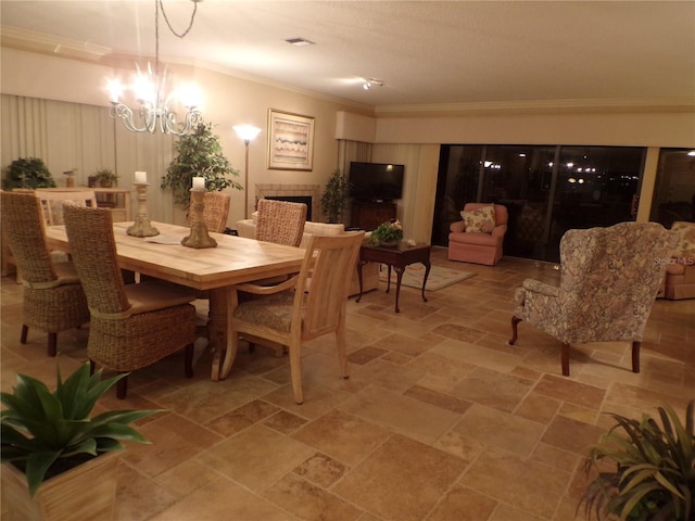 dining room featuring a chandelier, ornamental molding, and stone finish floor