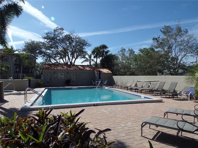 pool with a patio area and fence