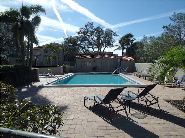 pool with fence and a patio