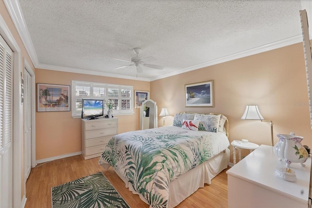 8140 Terrace Garden Dr N Unit 103, Saint Petersburg, FL 33709 - bedroom featuring light wood-style floors, a textured ceiling, crown molding, baseboards, and a ceiling fan