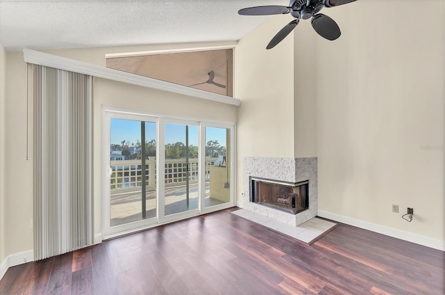 unfurnished living room featuring a multi sided fireplace, baseboards, wood finished floors, and ceiling fan