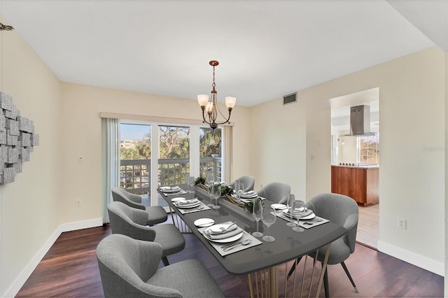 dining room with baseboards, visible vents, an inviting chandelier, and wood finished floors