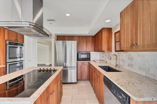 kitchen with visible vents, island exhaust hood, brown cabinets, a sink, and black appliances