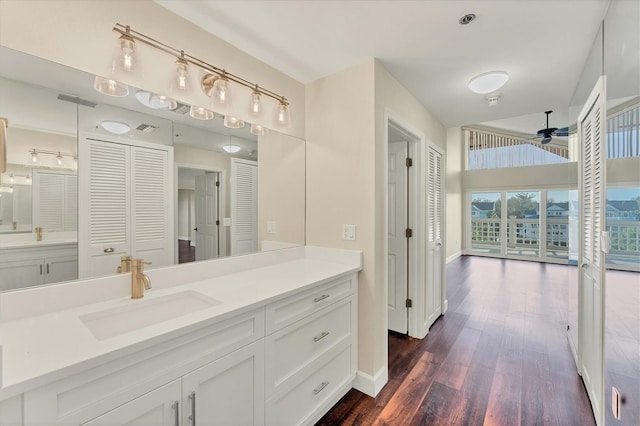 bathroom with vanity, baseboards, a ceiling fan, a closet, and wood finished floors