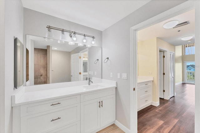 bathroom featuring vanity, baseboards, and wood finished floors
