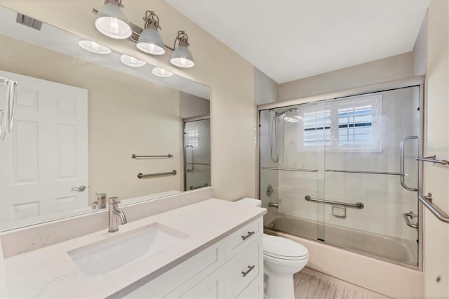 full bathroom featuring toilet, vanity, enclosed tub / shower combo, and visible vents