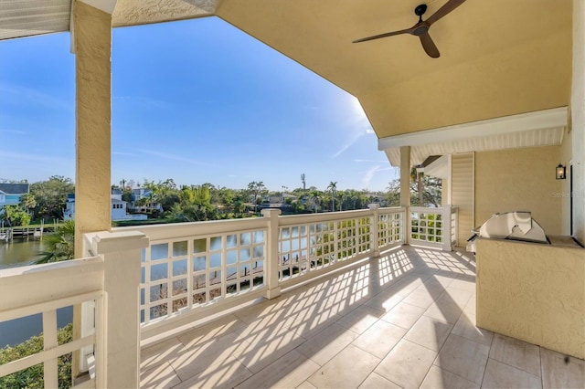 balcony featuring a water view and ceiling fan