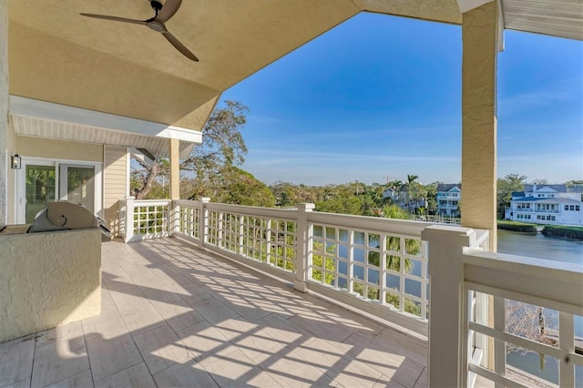 view of patio featuring a ceiling fan, a balcony, and a water view