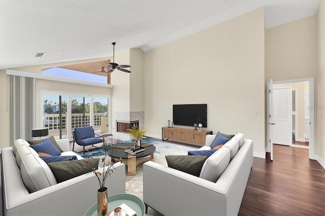 living room with high vaulted ceiling, dark wood-style floors, visible vents, and a ceiling fan