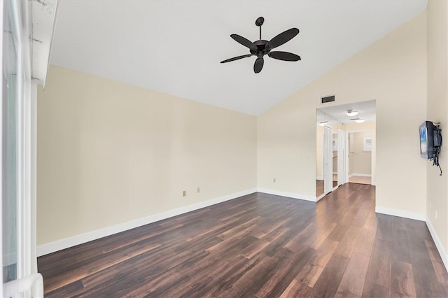 unfurnished room with lofted ceiling, baseboards, dark wood-style floors, visible vents, and a ceiling fan