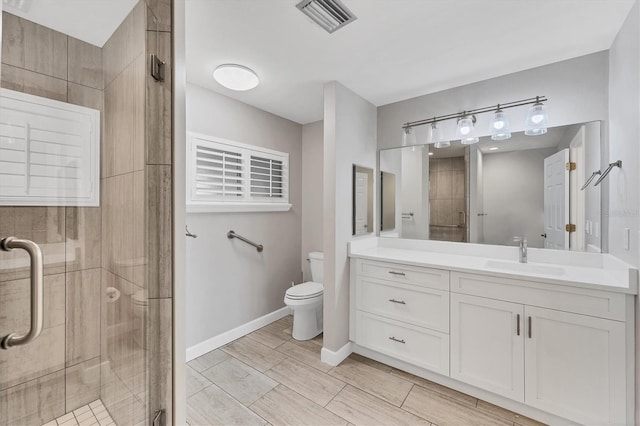 full bath with a stall shower, toilet, vanity, baseboards, and visible vents