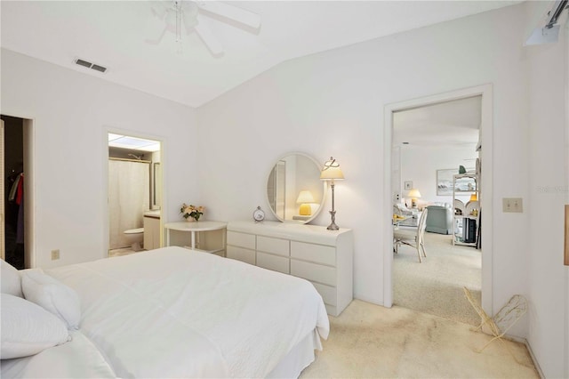 bedroom featuring ensuite bath, vaulted ceiling, visible vents, and light carpet