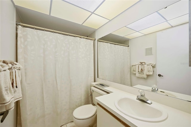 bathroom featuring vanity, toilet, visible vents, and a drop ceiling