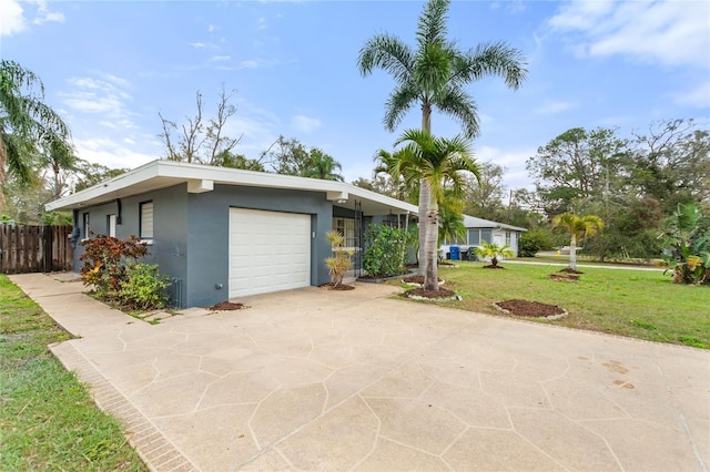 mid-century modern home with stucco siding, concrete driveway, fence, a garage, and a front lawn