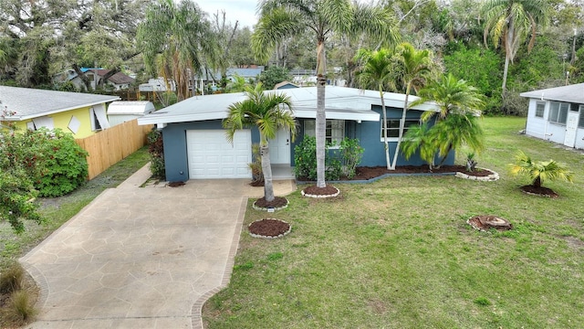 view of front of house with a garage, concrete driveway, fence, a front lawn, and stucco siding