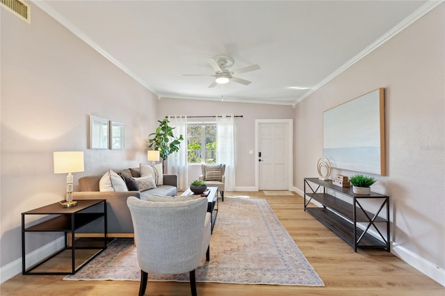 living area featuring ornamental molding, light wood-type flooring, visible vents, and baseboards