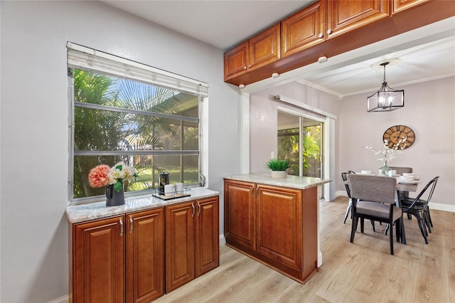 bar featuring ornamental molding, pendant lighting, light wood-style flooring, and baseboards