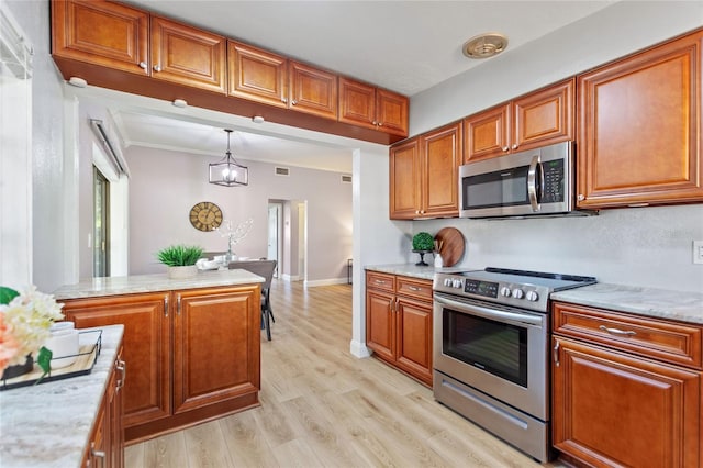 kitchen featuring light wood finished floors, light countertops, appliances with stainless steel finishes, and brown cabinets