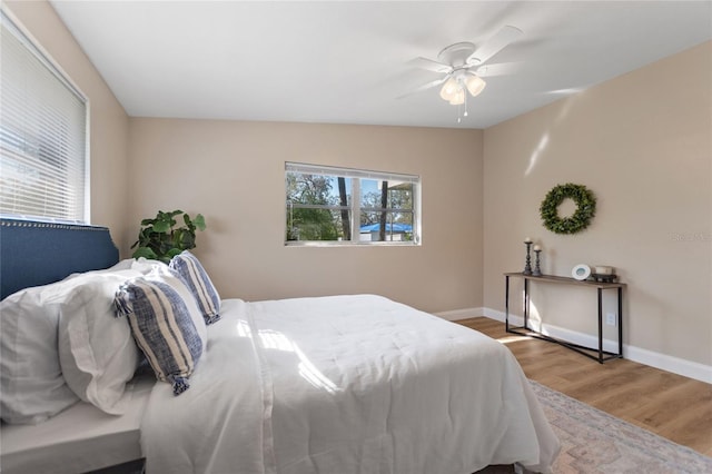 bedroom with ceiling fan, baseboards, and wood finished floors