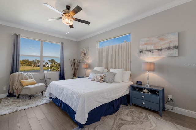 bedroom featuring ornamental molding, baseboards, and wood finished floors