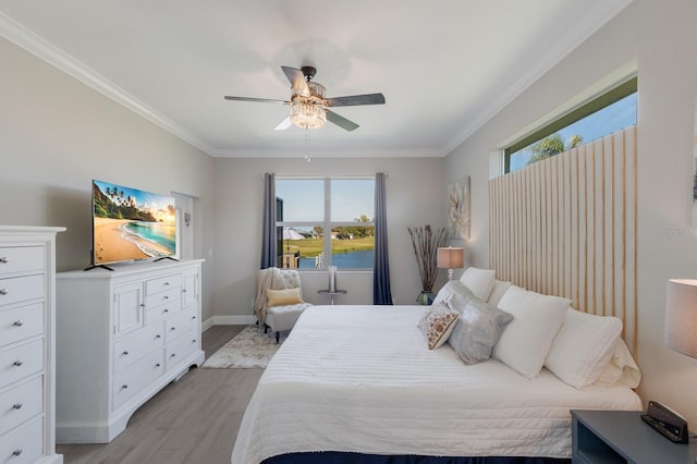 bedroom featuring a ceiling fan, baseboards, crown molding, and light wood finished floors