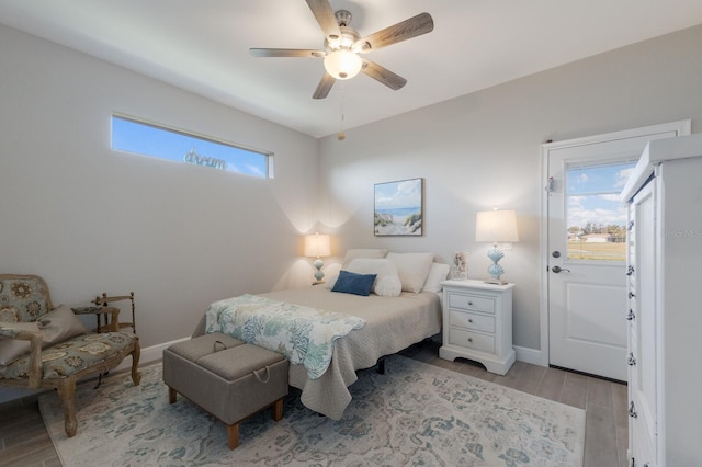 bedroom featuring light wood-style flooring, baseboards, and a ceiling fan