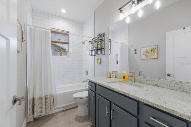 bathroom featuring toilet, shower / bath combo, wood finished floors, and vanity