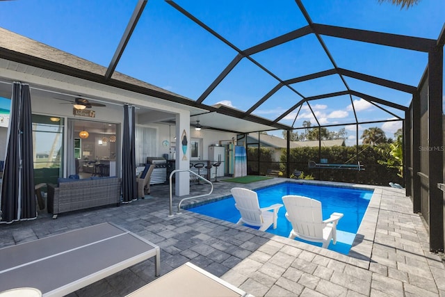 pool featuring glass enclosure, a ceiling fan, and a patio