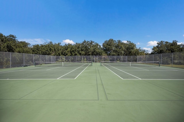 view of tennis court featuring fence