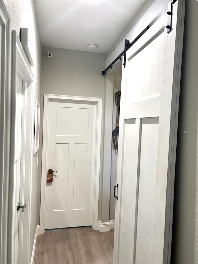 6 Bunker Cir, Rotonda West, FL 33947 - hallway with a barn door and wood finished floors