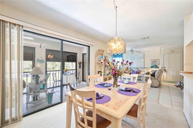 dining area with light tile patterned floors, light colored carpet, visible vents, and a textured ceiling