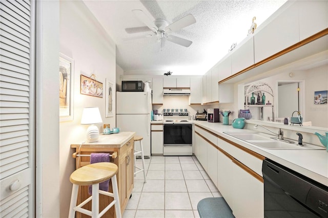 kitchen featuring under cabinet range hood, black appliances, light countertops, and light tile patterned flooring