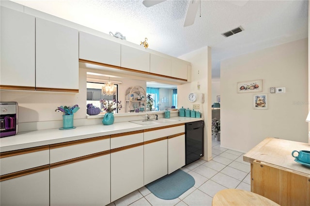 kitchen featuring visible vents, light countertops, white cabinets, black dishwasher, and a textured ceiling