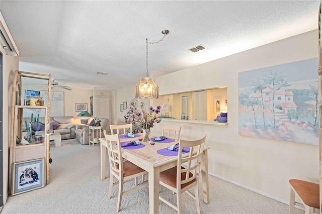 dining area with visible vents, baseboards, a textured ceiling, and carpet flooring